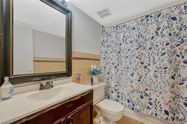 full bath featuring a textured ceiling, visible vents, tile walls, vanity, and toilet