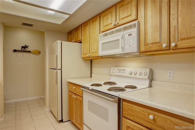 kitchen featuring light tile patterned floors and white appliances