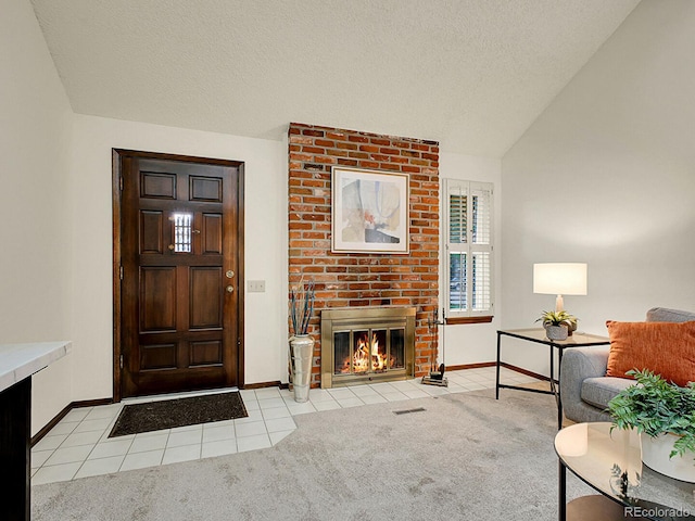 7781 S Curtice Dr Unit D, Littleton, CO 80120 - entrance foyer featuring light tile patterned flooring, a brick fireplace, vaulted ceiling, light colored carpet, and a textured ceiling