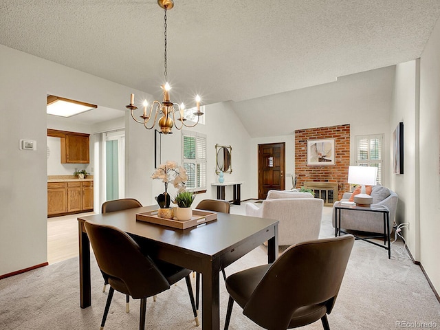 7781 S Curtice Dr Unit D, Littleton, CO 80120 - dining area featuring light colored carpet, a chandelier, a textured ceiling, vaulted ceiling, and a fireplace