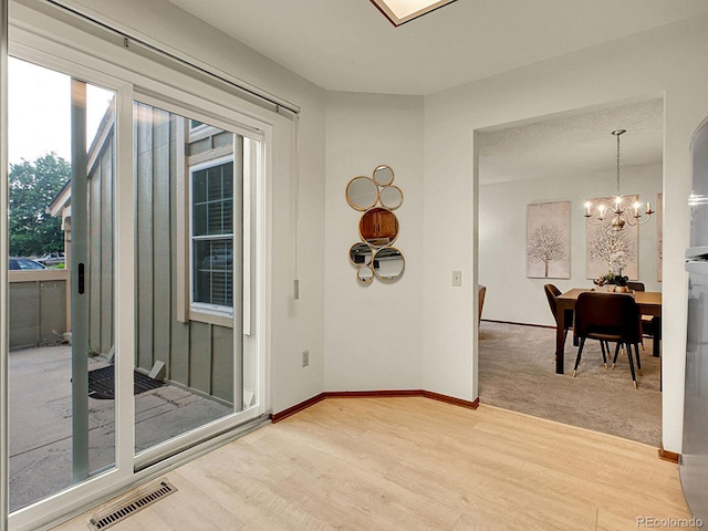 7781 S Curtice Dr Unit D, Littleton, CO 80120 - empty room featuring light wood finished floors and a chandelier