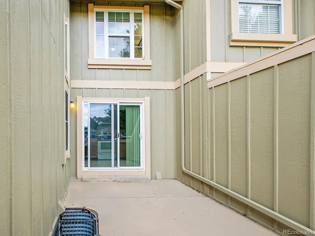 7781 S Curtice Dr Unit D, Littleton, CO 80120 - view of exterior entry featuring a patio and board and batten siding
