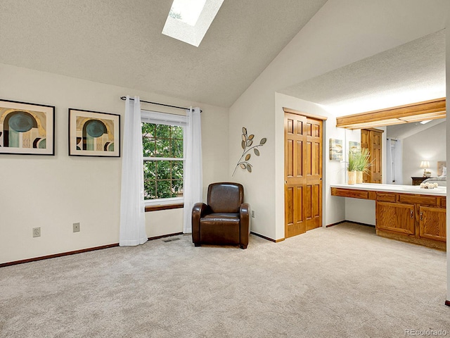 7781 S Curtice Dr Unit D, Littleton, CO 80120 - sitting room featuring vaulted ceiling, light carpet, a skylight, and a textured ceiling
