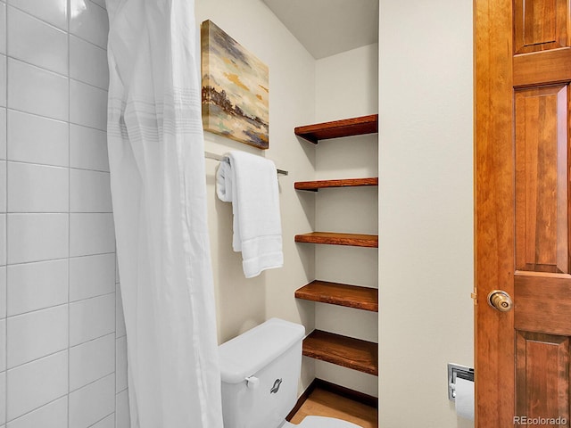7781 S Curtice Dr Unit D, Littleton, CO 80120 - bathroom with toilet and a shower with shower curtain