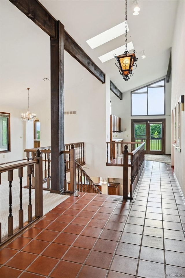 11621 Shoshone Way, Denver, CO 80234 - hallway with a chandelier, an upstairs landing, a skylight, high vaulted ceiling, and tile patterned floors