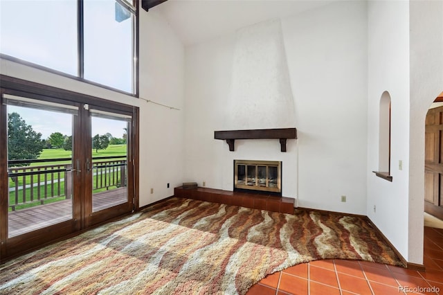 11621 Shoshone Way, Denver, CO 80234 - unfurnished living room with high vaulted ceiling, a large fireplace, view of golf course, carpet floors, and tile patterned floors