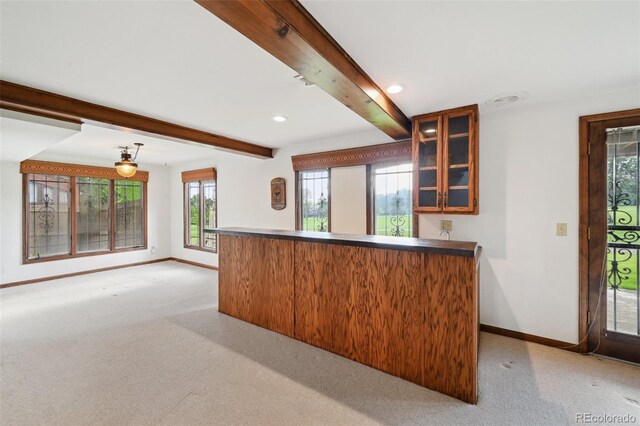 11621 Shoshone Way, Denver, CO 80234 - kitchen with beamed ceiling, glass insert cabinets, a peninsula, light colored carpet, and recessed lighting