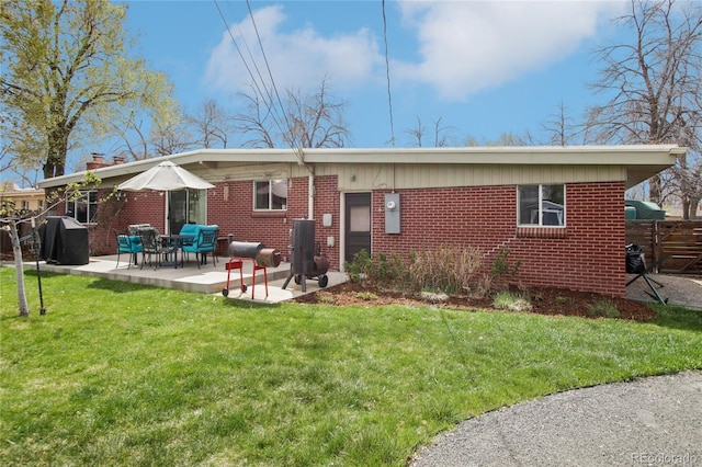 6188 S Westview St, Littleton, CO 80120 - rear view of property featuring brick siding, a patio area, a lawn, and fence