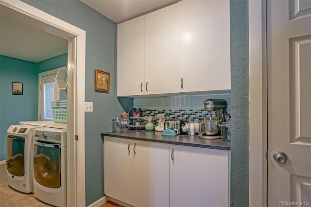 interior space with white cabinetry, washing machine and dryer, and tasteful backsplash