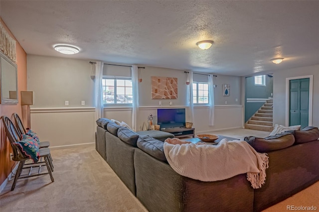 living room with a wealth of natural light, carpet floors, and a textured ceiling