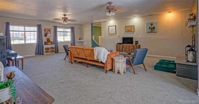 carpeted dining space with ceiling fan and a fireplace