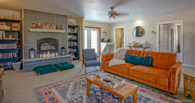 carpeted living room with ceiling fan and a tile fireplace