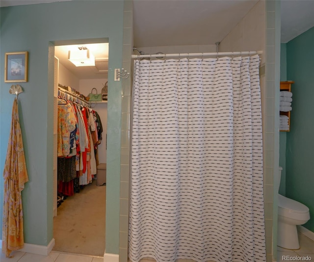 bathroom with toilet, walk in shower, and tile patterned flooring