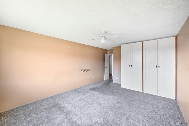 350 S Clinton St Unit 8C, Denver, CO 80247 - unfurnished bedroom with carpet floors, a ceiling fan, a textured ceiling, and multiple closets