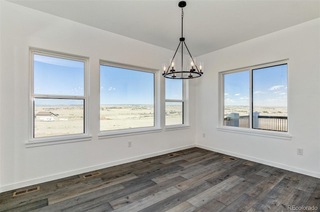 16990 Early Light Dr, Colorado Springs, CO 80908 - spare room featuring dark wood-style flooring, baseboards, an inviting chandelier, and visible vents