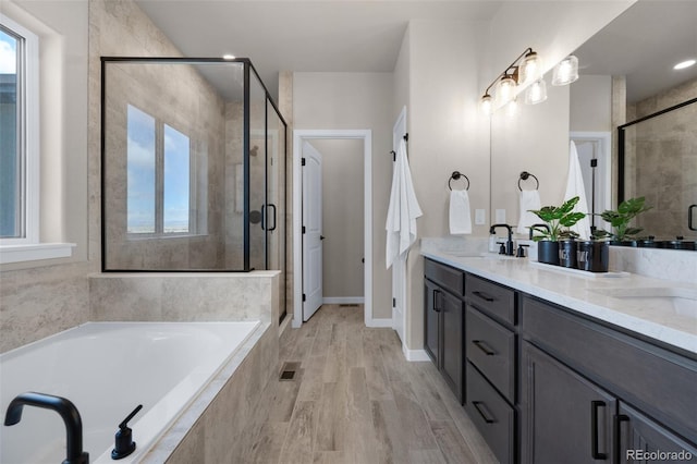 16990 Early Light Dr, Colorado Springs, CO 80908 - bathroom featuring visible vents, double vanity, a bath, a shower stall, and a sink