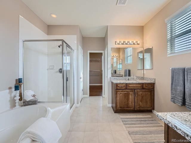 bathroom with tile patterned floors, vanity, and plus walk in shower