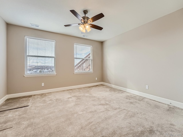 spare room featuring light carpet and ceiling fan