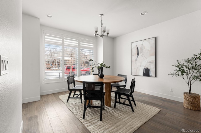 dining space with dark hardwood / wood-style floors and a notable chandelier