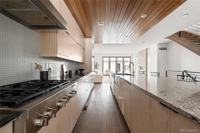 kitchen featuring wooden ceiling, stainless steel gas cooktop, backsplash, light stone counters, and dark hardwood / wood-style floors