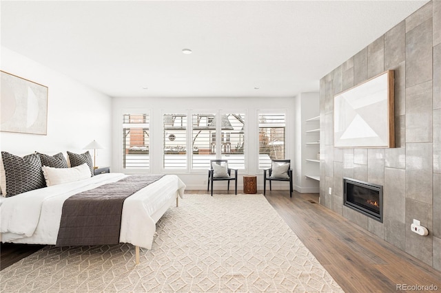 bedroom featuring light hardwood / wood-style flooring and a fireplace