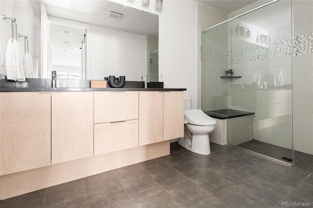 bathroom featuring vanity, toilet, and a tile shower