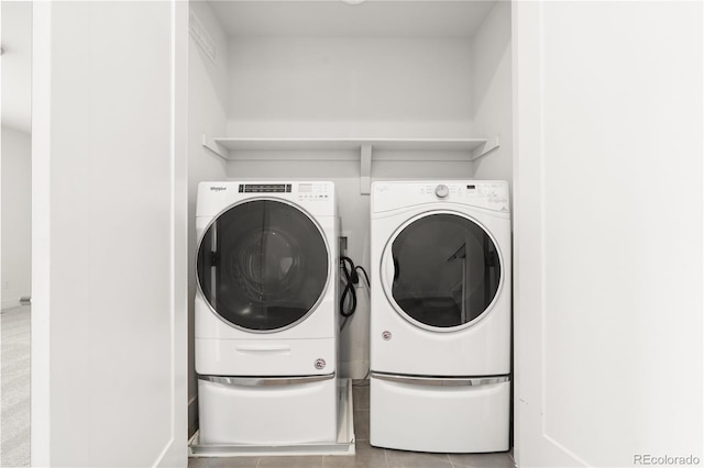 laundry room with washer and dryer and light tile patterned floors