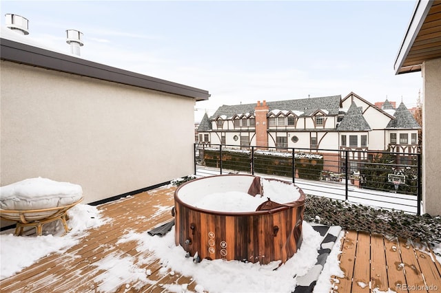 snow covered deck featuring a hot tub