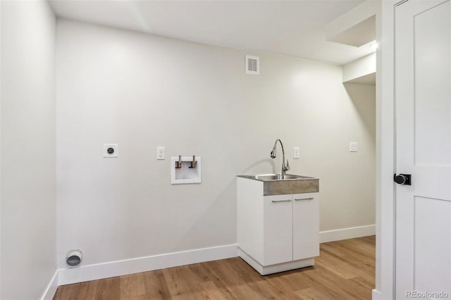 washroom with electric dryer hookup, hookup for a washing machine, light hardwood / wood-style flooring, and sink