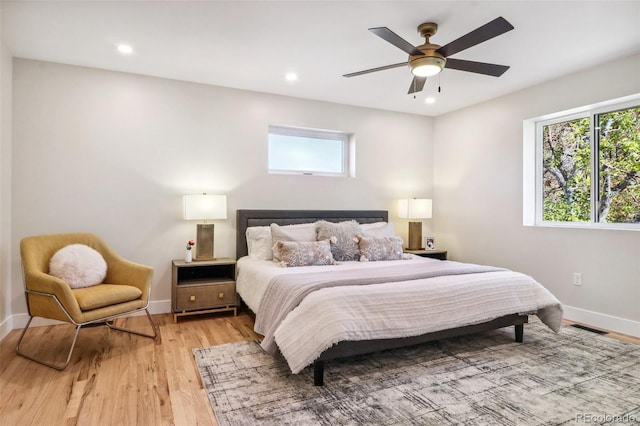 bedroom with light wood-type flooring, multiple windows, and ceiling fan