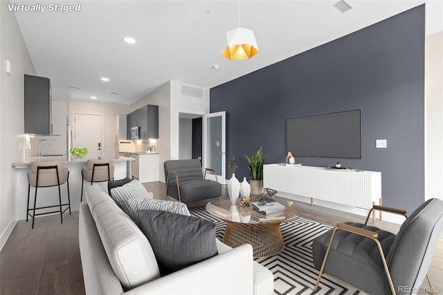 living room with hardwood / wood-style flooring and sink