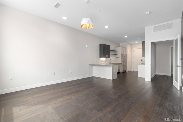 unfurnished living room with sink and dark wood-type flooring