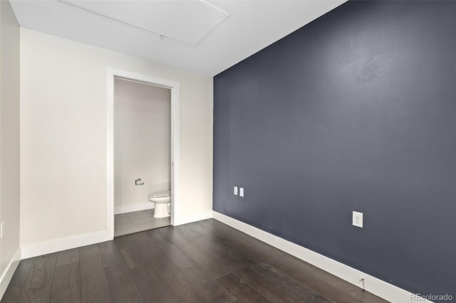 unfurnished bedroom featuring dark hardwood / wood-style floors and ensuite bath