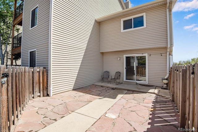 back of property with fence and a patio area