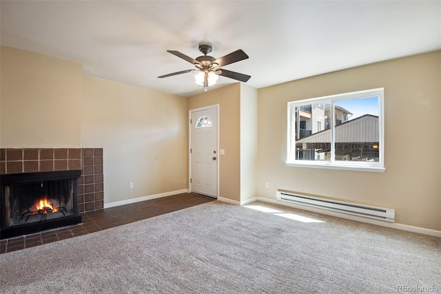 unfurnished living room featuring a tiled fireplace, baseboards, a baseboard heating unit, and carpet flooring