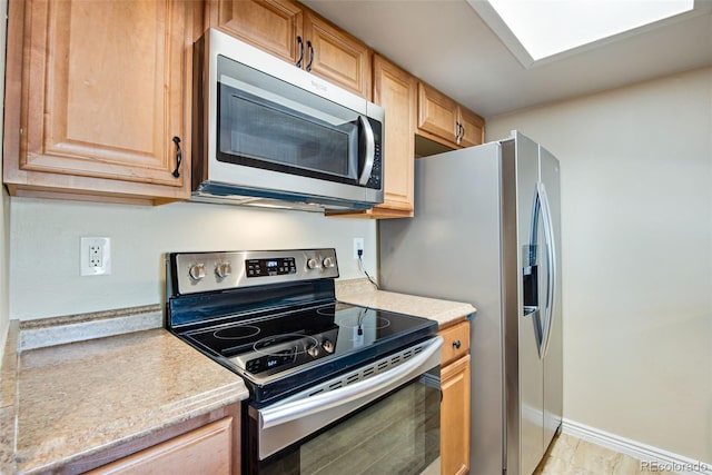 kitchen featuring light countertops, appliances with stainless steel finishes, and baseboards