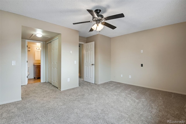 unfurnished bedroom featuring baseboards, ceiling fan, light carpet, and ensuite bath