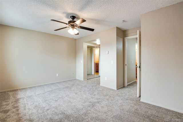 empty room featuring a textured ceiling, ceiling fan, light carpet, and baseboards