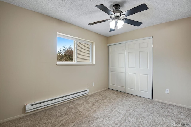 unfurnished bedroom with carpet, baseboard heating, a closet, and a textured ceiling