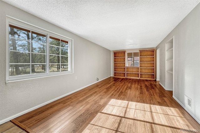 unfurnished bedroom with wood-type flooring and a textured ceiling