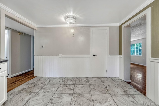 spare room featuring crown molding and a textured ceiling