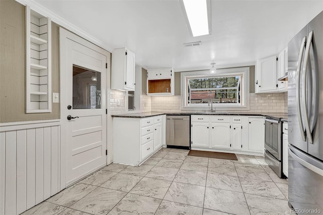 kitchen featuring sink, white cabinetry, stainless steel appliances, and tasteful backsplash