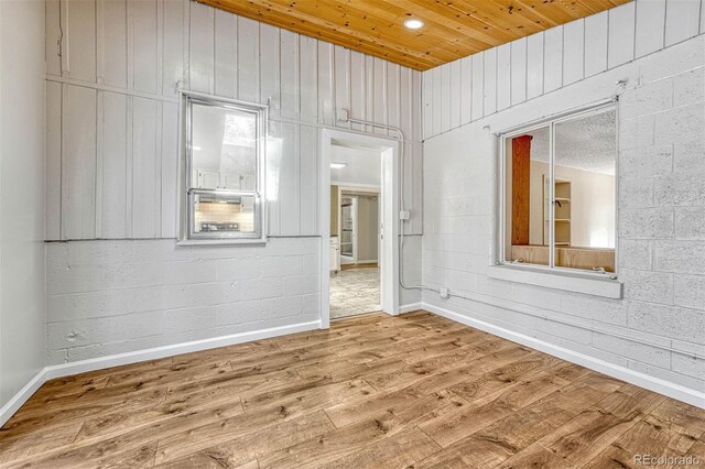 empty room with wood-type flooring and wooden ceiling