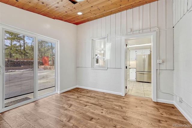 spare room featuring light hardwood / wood-style floors and wooden ceiling