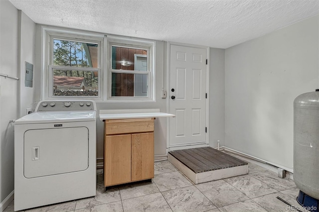 laundry room with cabinets, washer / dryer, and a textured ceiling