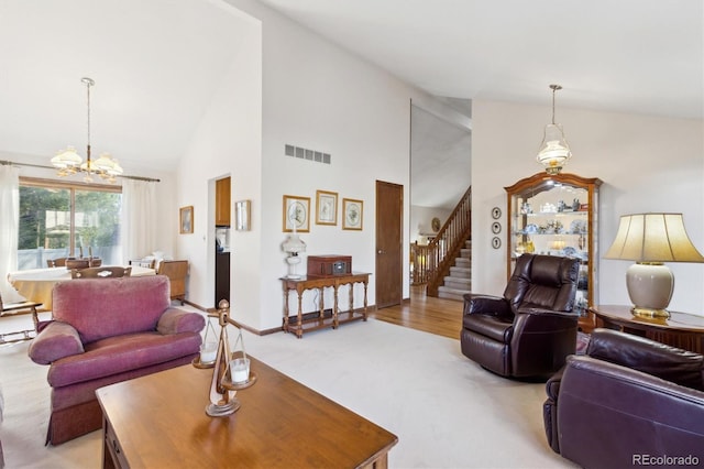 2013 S Holland St, Lakewood, CO 80227 - living area with stairs, high vaulted ceiling, visible vents, a chandelier, and light carpet