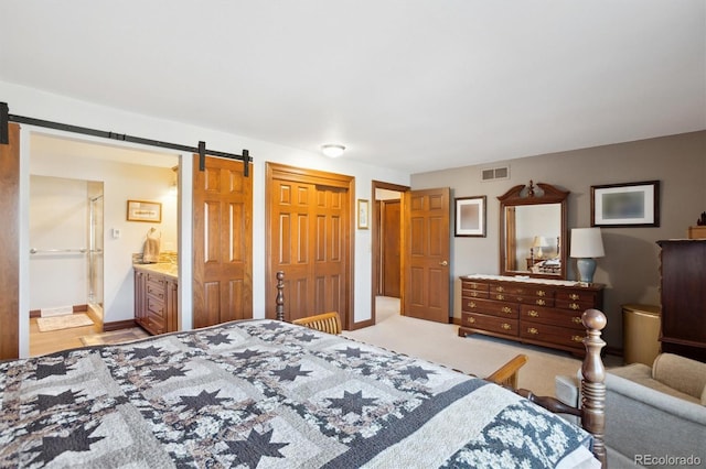 2013 S Holland St, Lakewood, CO 80227 - bedroom with a closet, ensuite bathroom, visible vents, a barn door, and baseboards