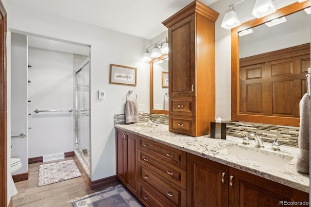 2013 S Holland St, Lakewood, CO 80227 - bathroom with double vanity, wood finished floors, a shower stall, and a sink