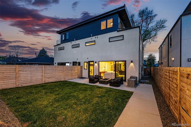 rear view of house featuring outdoor lounge area, a patio area, stucco siding, and central AC
