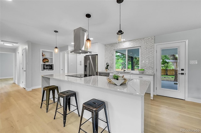 6526 S Elmwood St, Littleton, CO 80120 - kitchen featuring stainless steel appliances, island range hood, a sink, white cabinetry, and a breakfast bar